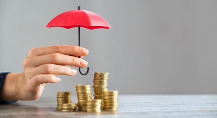 Parasol nad stosem monet na stole jako symbol ochrony kapitału – endofund.pl